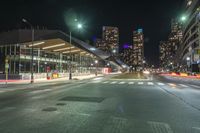 the empty street in front of a terminal with some buildings in the background at night