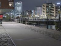 the pier of the city with ships is lit up at night with people sitting and walking