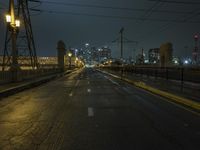 a night street is lit with lights and wires on poles for the power lines to go over