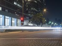 long exposure of a street at night with light streaks and buildings on the other side