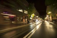 motion bluring image of street at night in city, as seen from a moving car