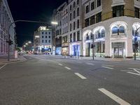 a street is empty of people or cars at night time and is lit up with lights