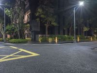 a corner with a parking lot at night with parking lights on and a street in front