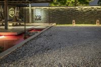 this is an outdoor area with concrete walls and a gravel driveway and a red lighting shines down