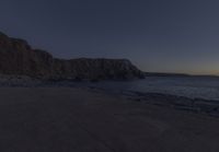 a bench that is in front of some rocks and water at sunset with the moon and trees