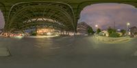 there is a picture taken under the bridge at night time, looking like a fisheye view