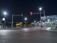 large building on the street with lights in front and other buildings nearby at night with no one moving