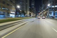 a long - shot picture of cars moving along a street at night time as seen from the car window