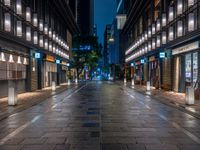 a large brick sidewalk with a store front at night time and a sign that says