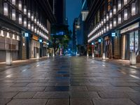 a large brick sidewalk with a store front at night time and a sign that says