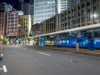 empty street at night in modern city with skyscrapers and office building across the street