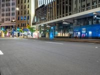 empty street at night in modern city with skyscrapers and office building across the street