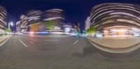 a city street at night with several cars traveling by as well as the time lapse