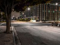 the city streets are empty of cars and stop lights at night time in the distance