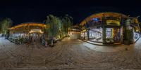 a 360 - view image shows several different shops and buildings lit up at night time