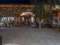 a store front on the side of a street at night with lights in the windows