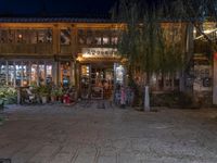 a store front on the side of a street at night with lights in the windows