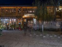 a store front on the side of a street at night with lights in the windows