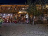 a store front on the side of a street at night with lights in the windows