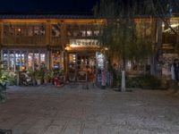 a store front on the side of a street at night with lights in the windows