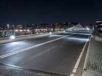 a highway and some tall buildings in the night sky with a person riding a scooter at the end of a ramp