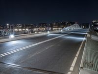 a highway and some tall buildings in the night sky with a person riding a scooter at the end of a ramp