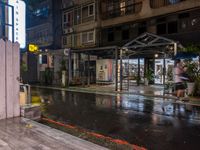 rain falls onto the street as it passes by a building on a rainy night in tokyo