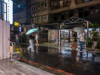 rain falls onto the street as it passes by a building on a rainy night in tokyo