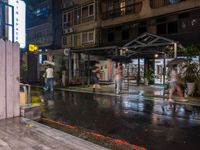 rain falls onto the street as it passes by a building on a rainy night in tokyo