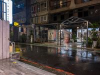 rain falls onto the street as it passes by a building on a rainy night in tokyo