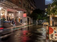 rain falls onto the street as it passes by a building on a rainy night in tokyo