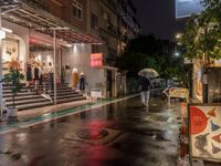 rain falls onto the street as it passes by a building on a rainy night in tokyo