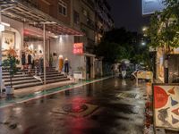 rain falls onto the street as it passes by a building on a rainy night in tokyo