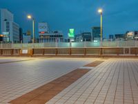 people standing on a subway platform with many buildings in the background at night light in tokyo