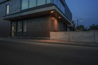 an illuminated street corner and a building at night with some light shining in it's windows