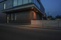 an illuminated street corner and a building at night with some light shining in it's windows