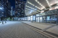 a night scene of the sidewalk next to the building and sidewalk near it in the city