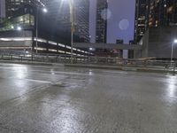 an empty street near several tall buildings at night time in the city with a sky background