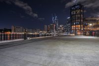 a city skyline at night seen from a waterfront park walkway along the hudson river by twilight