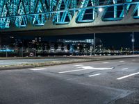 a man riding his bike underneath the bridge above a street at night time during the day