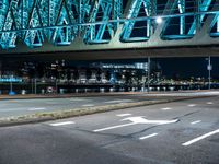 a man riding his bike underneath the bridge above a street at night time during the day