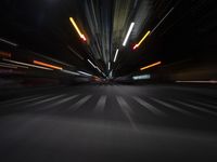 a large bus driving through an intersection near street lamps on the road at night time