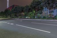 a city street with buildings and neon lights at night time in hong china as seen from an empty city highway