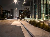 a long walk leads to a parking space next to an office building at night in the city