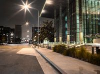 a long walk leads to a parking space next to an office building at night in the city