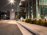 a long walk leads to a parking space next to an office building at night in the city