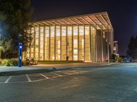 a picture of a large building lit up in evening light at night time with trees