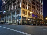 the street lights are showing bright blue and purple in a city at night time by the water