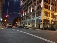 the street lights are showing bright blue and purple in a city at night time by the water