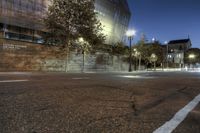 street light and concrete wall on the corner of a road at night time in front of the building